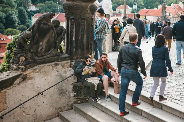 Прага, 18 сентября 2017 года: Уставшие мужчина и женщина или туристы сидят на лестнице и отдыхают. Другие люди занимаются повседневной деятельностью . — стоковое фото