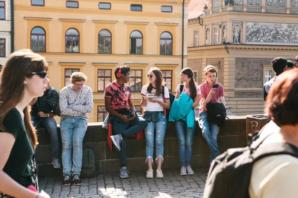 Чехия, Прага - 29. 09. The Last 2017 год. Группа молодых людей, отдыхающих на мощеной набережной в солнечный день — стоковое фото