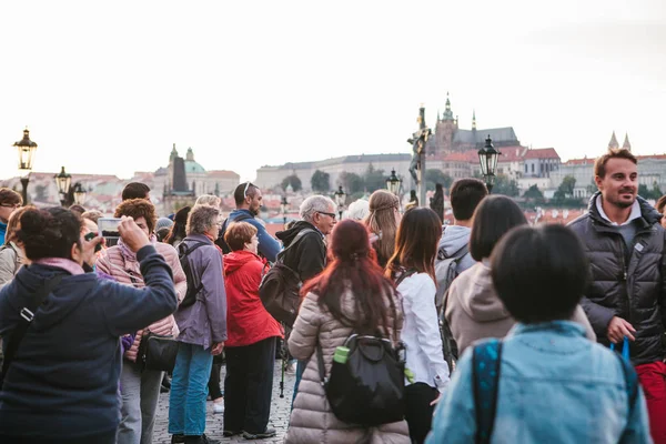 Прага, 18 сентября 2017 года: Туристы наслаждаются средневековой архитектурой на Карловом мосту. Кто-то фотографирует достопримечательности — стоковое фото