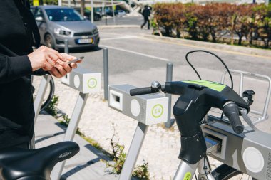 Portekiz, Lizbon 29 Nisan 2018: adam ya da turistik kiralar telefonunuzda mobil app kullanarak bisiklet veya şehir alternatif ekolojik Taşımacılık/Nakliyat