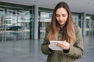 Güzel bir genç kadın arkadaşlarıyla iletişim kurmak için bir tablet kullanır ya da haritaya benziyor veya çağıran bir taksi veya başka bir şey
