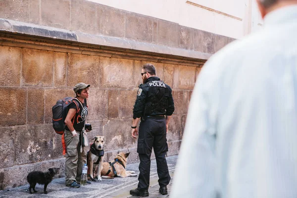 Прага, 29 сентября 2017 года: Полицейский разговаривает с бездомным или проверяет его документы . — стоковое фото