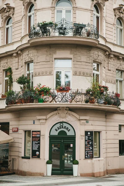 Прага, 24 сентября 2017 года: Уголок традиционного здания с чешской архитектурой с балконами и цветами. Вход в аутентичное кафе на углу здания — стоковое фото