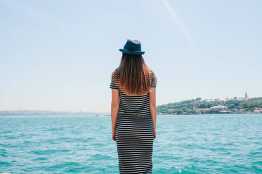 Şapkalı bir genç güzel kız bir tatil Türkiye ve Boğaz'ın ve Istanbul uzaktan güzel manzaralarını keyif alıyor