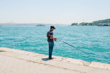 Istanbul, 17 Haziran 2017: Geleneksel Türk Balıkçılık hobi. Yerel balıkçı kıyıda balık tutuyor. Türkiye'de sıradan yaşam