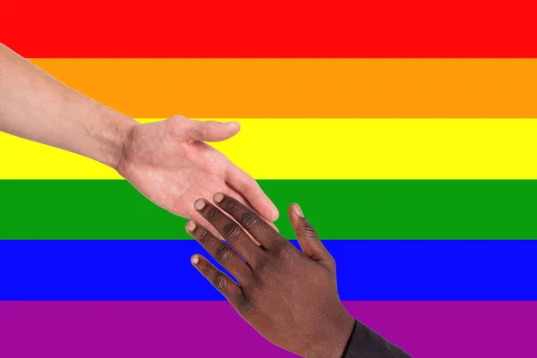 Люди разных национальностей служат друг другу на фоне флага ЛГБТ. Концепция помощи, поддержки, свободы прав человека — стоковое фото