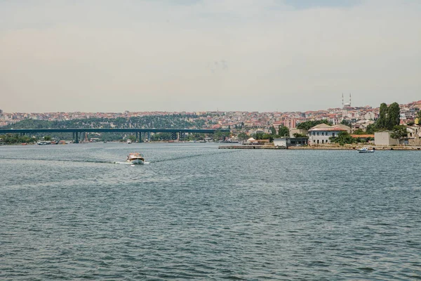 一艘快艇沿着伊斯坦布尔的一条船驶过。城市建筑背景 — 图库照片