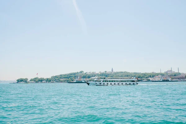 一艘轮船或一条客轮沿着伊斯坦布尔的那座船驶过。城市建筑背景 — 图库照片