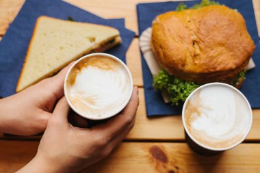 Kızı kahve tutuyor. Yakın bir sandviç ve hamburger yalan. Fast food