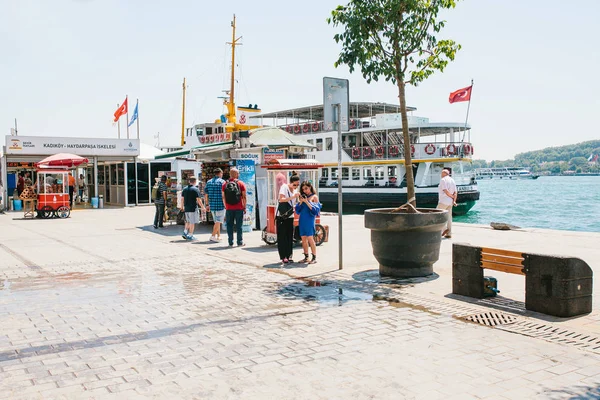 Κωνσταντινούπολη, 17 Ιουνίου 2017: Δύο κορίτσια φίλοι συναντήθηκαν και κάθε άλλο δείξει κάτι στο κινητό τηλέφωνο. Κοντινά άτομα που περπατούν γύρω από. Το επιβατηγό πλοίο βρίσκεται στο παρασκήνιο. Απλοί πόλη ζωής — Φωτογραφία Αρχείου