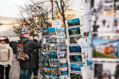 Berlin, Almanya 15 Şubat 2018: kartpostallar ve Hatıra Eşyası sokak satışı. Alıcı bellek için bir kart seçer