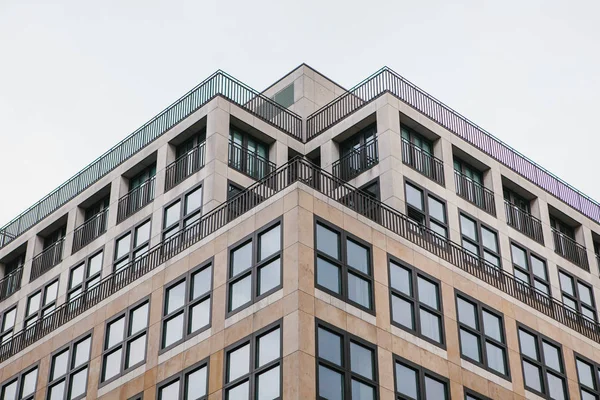Simetrik bir anlık görüntüsünü windows gökyüzüne karşı dolu bir bina köşe — Stok fotoğraf