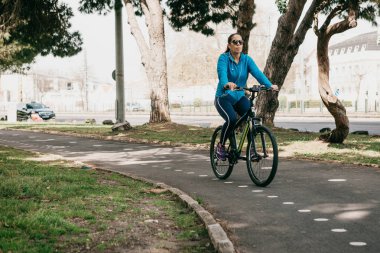 Lisbon, 18 Haziran 2018: Bir kadın Belem şehir parkında bir bisiklet sürme. Yerel halk günlük spor faaliyetleri.