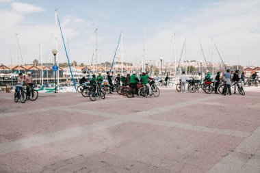 Lisbon, 18 Haziran 2018: Bisiklet üzerinde turist bir grup ya da sporcular şehrin Belem bölgesinde sahildeki güzel manzarasına hayran