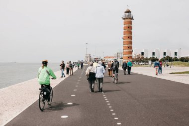 Lisbon, 18 Haziran 2018: İnsanlar gezinti Belem alanında alan gezinti yolu üzerinde. Bazı insanlar bisiklet sürmek. Sıradan şehir hayatı