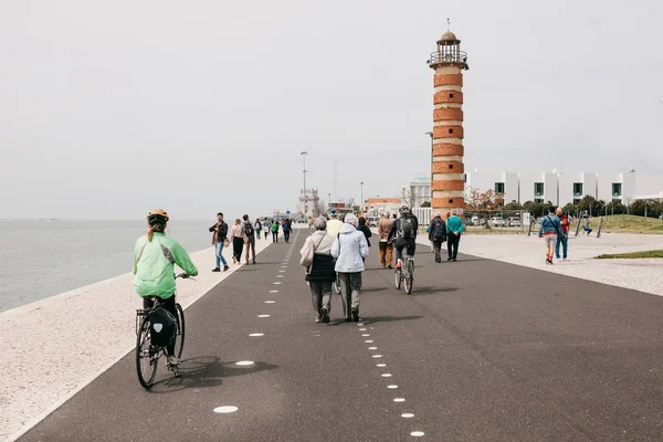 Lisbon, June 18, 2018: People stroll along the promenade in the Belem area. Some people ride bicycles. Ordinary city life — Stock Photo, Image