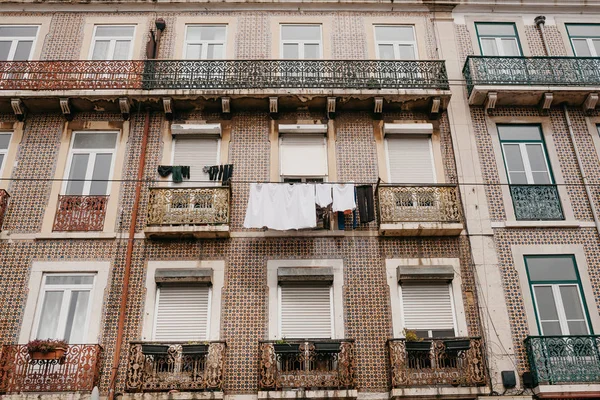 Authentic photography. Clothes dry on the facade of an apartment building in Lisbon in Portugal. The characteristic feature of the Portuguese is everywhere to hang out clothes and linen to dry.