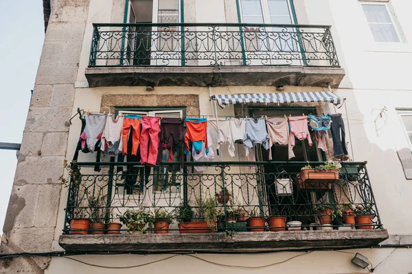 Authentic photography. Clothes dry on the facade of an apartment building in Lisbon in Portugal. The characteristic feature of the Portuguese is everywhere to hang out clothes and linen to dry.