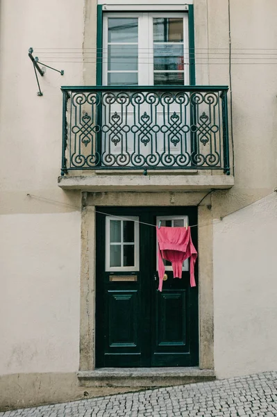 Hiteles fotózás. Ruhák száraz, a bejáratnál, hogy egy bérház Lisszabonban, Portugáliában. A portugál jellemző tulajdonsága mindenhol lógni ruházat, textília, száraz. — Stock Fotó