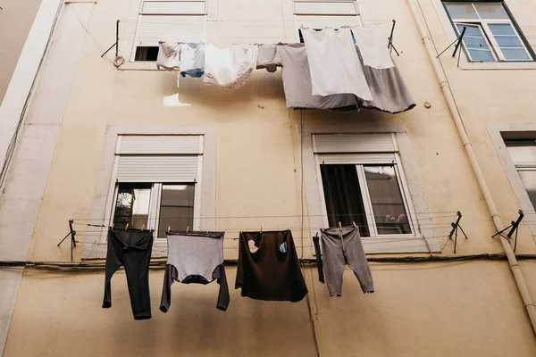 Authentic photography. Clothes dry on the facade of an apartment building in Lisbon in Portugal. The characteristic feature of the Portuguese is everywhere to hang out clothes and linen to dry.