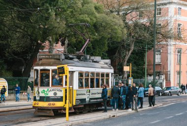 Lisbon, 18 Haziran 2018: yerli deneme tramvay durağında kalabalık eski moda sarı tramvay içine almak için. Her zamanki günlük şehir hayatı