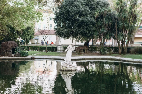 Fonte ou lago com estátua em Lisboa. Paisagismo ou arquitetura ou parque e jardim. Estátua antiga em água ou ornamento em parque e sistema hidráulico — Fotografia de Stock