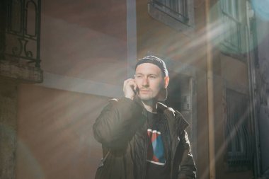 Telefonda bir şehirde sokak konuşan genç bir adam portresi