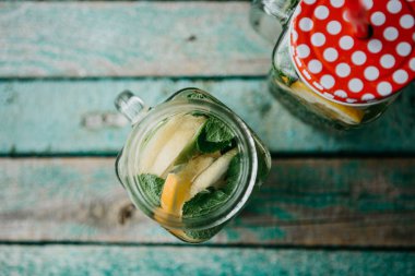 Ev yapımı narenciye limonata veya meyve suyu veya bir ahşap yüzeyde bir kavanoza mojito. Narenciye içki.