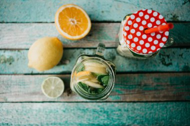 Ev yapımı narenciye limonata veya meyve suyu veya bir ahşap yüzeyde bir kavanoza mojito. Narenciye içki.