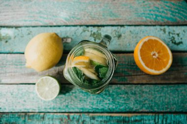 Ev yapımı narenciye limonata veya meyve suyu veya bir ahşap yüzeyde bir kavanoza mojito. Narenciye içki.
