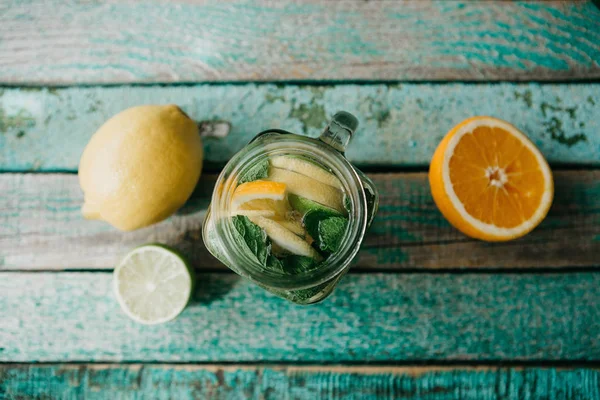 Limonata di agrumi fatta in casa o succo di frutta o mojito in un barattolo su una superficie di legno. Bevanda da agrumi . — Foto Stock