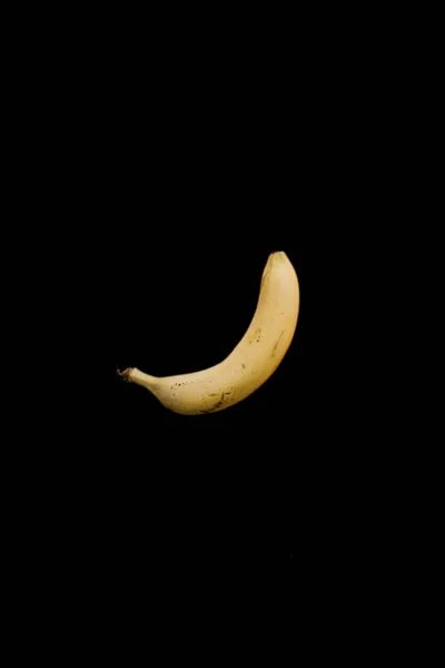 黒の背景に単一の黄色熟したバナナ — ストック写真