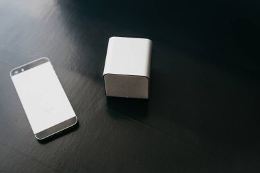 Radyo sözcü ve yanlarında cep telefonu karanlık bir arka plan üzerinde. Bir cep telefonu müzik dinlemek için Modern teknoloji