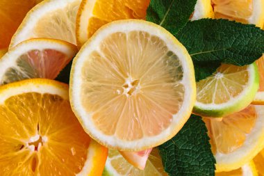Narenciye arka plan. Birçok dilim limon, portakal, limon ve nane yaprakları yalan birlikte. Bir sürü meyve. Sağlıklı yemek ve vitaminler