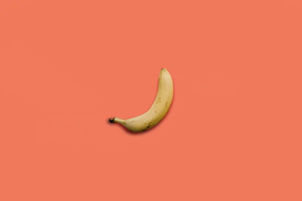 ピンクの背景の 1 つの黄色熟したバナナ — ストック写真
