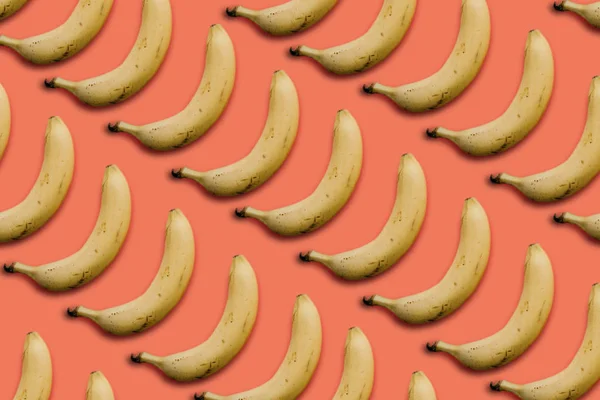분홍색 배경에 행에 많은 바나나 — 스톡 사진