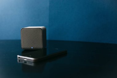 Bir kablosuz hoparlör ve karanlık bir arka plan bir cep telefonundan yanında. Bir cep telefonu müzik dinlemek için Modern teknoloji