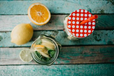 Ev yapımı narenciye limonata veya meyve suyu veya bir ahşap yüzeyde bir kavanoza mojito. Narenciye içki.