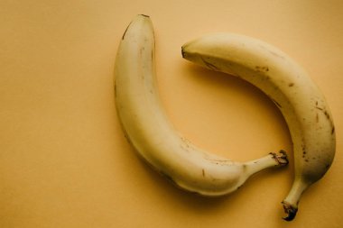 İki olgun muz sarı bir arka plan üzerinde. Sağlıklı ve besleyici yiyecek