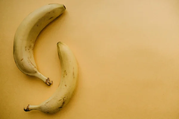 背景が黄色に熟したバナナを 2 つ。栄養価の高い、健康食品 — ストック写真