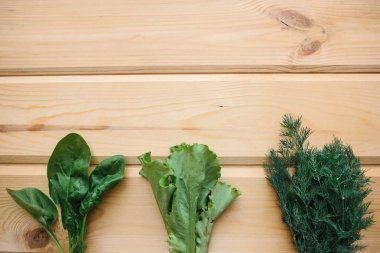 Ispanak, yeşil salata ve dereotu bir ahşap yüzeyde. Yeşiller karışımı. Sağlıklı gıdalar. Bir metin yukarıda yer