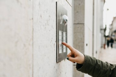 Kadın el baskıyı doorphone düğmesini kapatın. Kız interkom arıyor