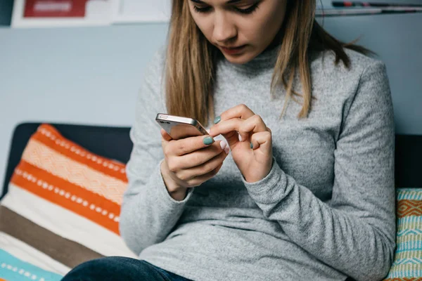 Una chica utiliza un teléfono celular para llamar o enviar un mensaje o para comunicarse en una red social o utiliza la aplicación — Foto de Stock