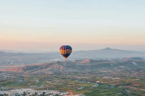 Voo de um balão solitário no céu pela manhã ao nascer do sol ou à noite ao pôr do sol. Viajar por via aérea ou aventura — Fotografia de Stock