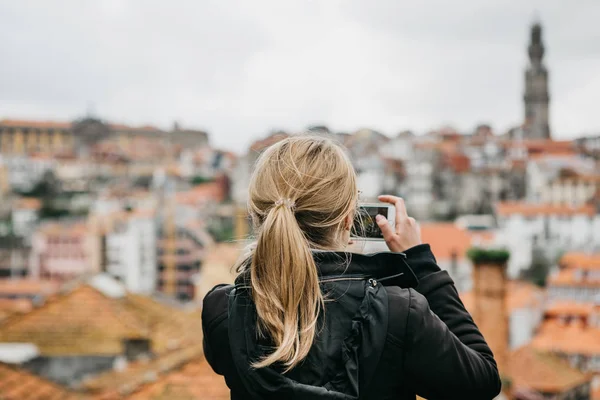 A megfigyelő fedélzetre egy turista lány veszi a képek a gyönyörű kilátás nyílik a város Porto, Portugália-ban egy mozgatható telefon — Stock Fotó