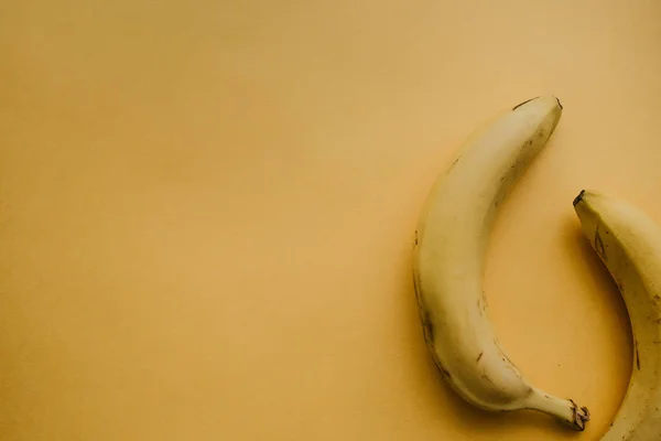 背景が黄色に熟したバナナを 2 つ。栄養価の高い、健康食品 — ストック写真