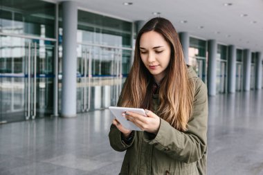 Güzel bir genç kadın arkadaşlarıyla iletişim kurmak için bir tablet kullanır ya da haritaya benziyor veya çağıran bir taksi veya başka bir şey