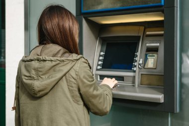 Genç bir kadın bir Atm. çekimden para Atm. finans, kredi kartı, para çekilmesi kartından alır..