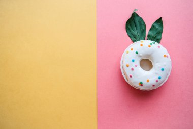 En az bir tarzda renkli bir arka plan üzerinde bir tavşan benzeyen yaprakları kulakları ile yaratıcı bir çörek. Metin için yakındaki yer