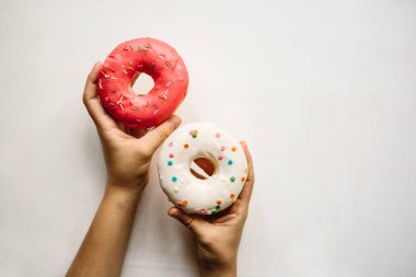 Kız çörek ellerinin beyaz bir arka plan üzerinde tutuyor